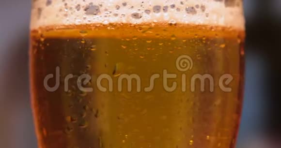 在装有水滴的玻璃杯里放冷光啤酒工艺啤酒特写旋转视频的预览图
