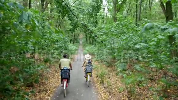 法国家庭爸爸妈妈戴着帽子和衣服带着一篮子花和小孩子一起骑自行车视频的预览图