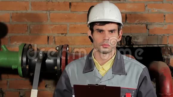 一个英俊的男性黑发白种人工程师严肃的肖像工人戴着头盔和耳机特写肖像视频的预览图