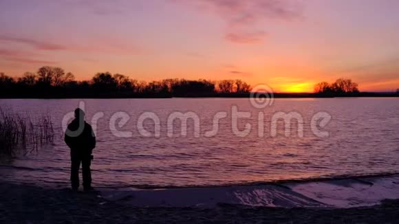 老人欣赏海滩上的日出美丽的炽热日落视频的预览图