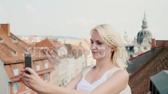 一个年轻的女人站在奥地利的老欧洲城市格拉茨的背景下欧元旅费视频的预览图