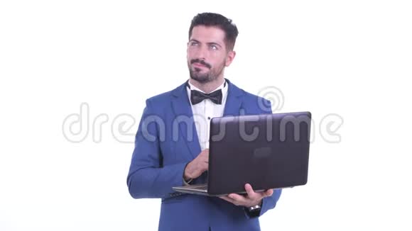 快乐的年轻大胡子商人在用笔记本电脑思考视频的预览图