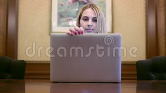 女商人打开笔记本电脑看着屏幕视频的预览图