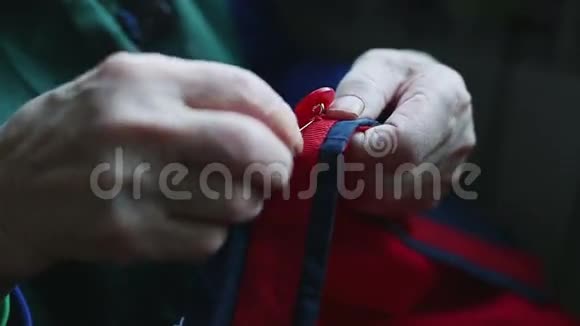 一个非常老的女人的手紧紧地缝在纽扣上视频的预览图
