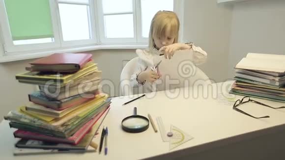 严肃的女孩用剪刀剪纸的图形视频的预览图