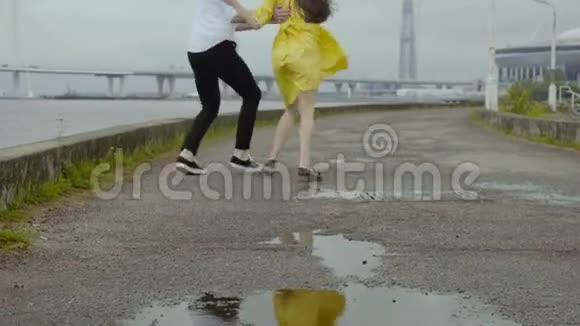 穿着黄色衣服的年轻男女在城市的河边跳舞视频的预览图