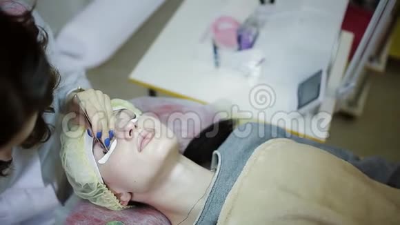 睫毛延伸化妆师拿着钳子把人造睫毛贴在女人身上视频的预览图
