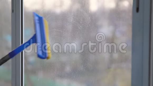 戴着黄手套的女人洗一个专用拖把的窗户视频的预览图