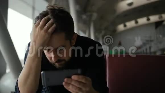 年轻人用智能手机在机场检查自己的发型视频的预览图