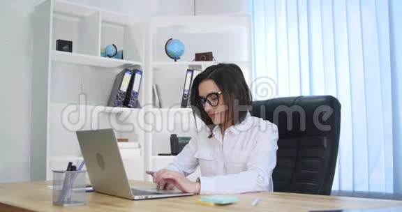 积极的成人商务男女同事坐在办公桌上手提电脑视频的预览图