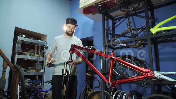 一个年轻的男工在他的车间装配一辆自行车视频的预览图