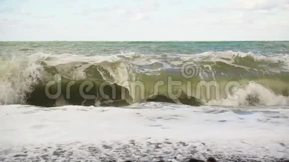 一股巨浪正在围绕着卵石滩缓缓移动视频的预览图