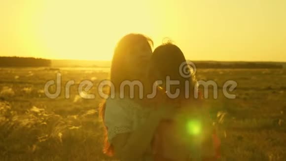 幸福的母亲和她的女儿在夕阳的照耀下抱在怀里散步妈妈在和快乐的宝贝说话宝贝视频的预览图