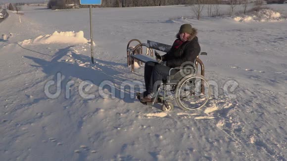 坐轮椅的残疾人在公共汽车站附近用平板电脑说话视频的预览图