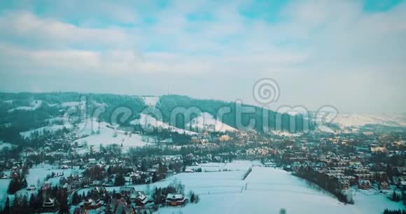 冬天雪中山和一个小镇的电影院视频的预览图