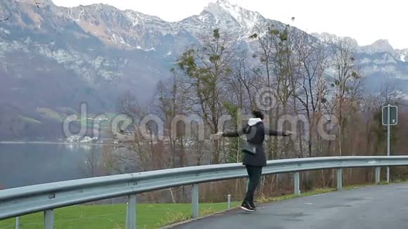 有趣的女孩在美丽的风景背景下跳舞阿尔卑斯山视频的预览图