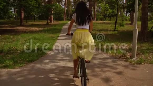 女性骑自行车在阳光下骑自行车视频的预览图