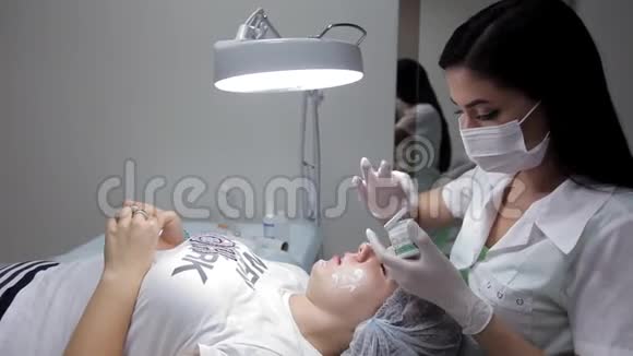 化妆师在生物杀菌前对女孩面霜进行润滑恢复进程的程序视频的预览图