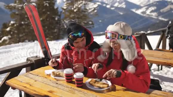 在山上的几个滑雪者在户外餐馆吃午饭视频的预览图