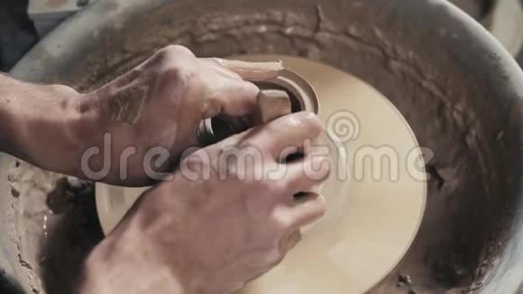 陶工师傅的手和陶土花瓶在陶工的车轮特写克罗克大师扭曲锅的车轮视频的预览图