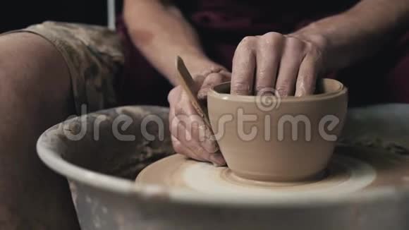 陶工在陶工的车轮上用陶制工具塑造陶制品顶部视图色调的电影工艺工厂视频的预览图