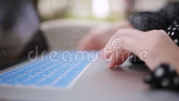 一位年轻女士在咖啡馆里用现代蓝色笔记本电脑工作视频的预览图