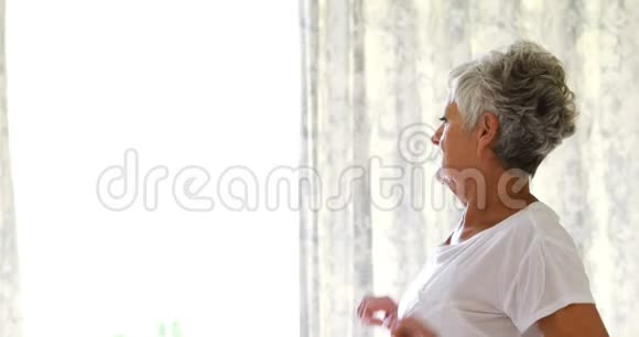 年长的女人醒来在床上伸展身体视频的预览图