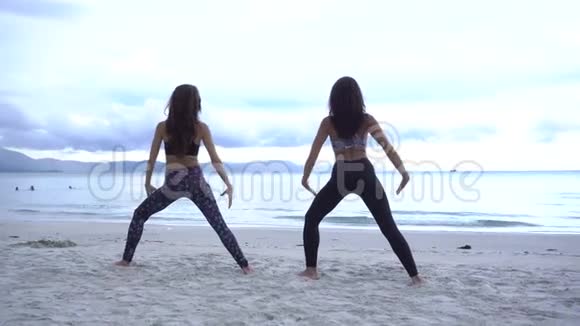 两个女人在海滩上练习瑜伽视频的预览图
