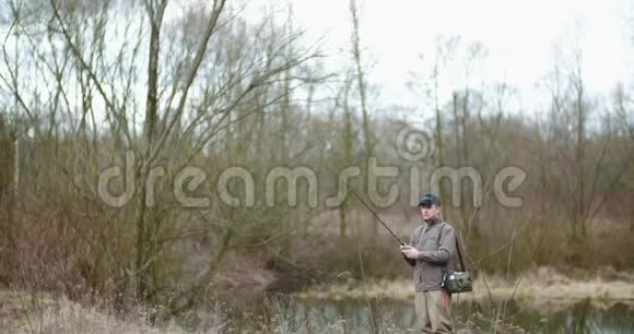 人在森林中的湖岸捕鱼视频的预览图