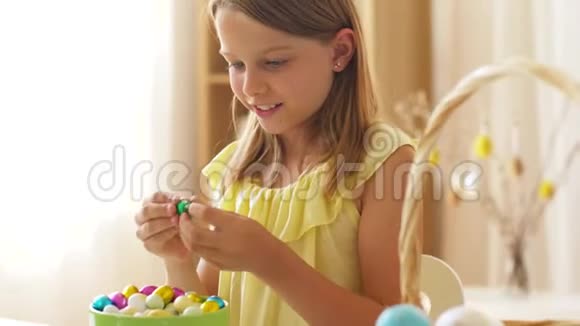 女孩去除巧克力复活节彩蛋的包装纸视频的预览图