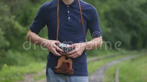 一名男子摄影师在背景轨道上拿着一架老式相机视频的预览图