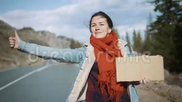 女孩搭便车持有人拿着一块没有铭文的纸板一个空座位带着背包独自旅行视频的预览图