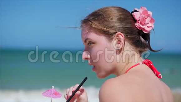 在阳光下喝椰子中的欧洲美丽可爱的布鲁内特年轻女性或快乐女孩的特写镜头视频的预览图