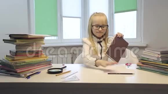 桌旁戴眼镜的活泼的女学生视频的预览图