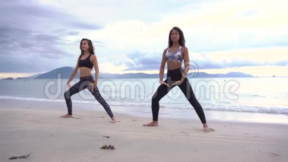 两个女人在海滩上练习瑜伽视频的预览图