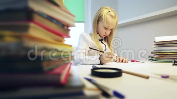 聪明的女学生在白桌子上做作业视频的预览图