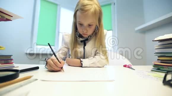 美丽的金发女孩穿着校服坐在桌子旁用铅笔画画视频的预览图