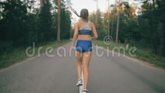 年轻女子在城市公园慢跑森林慢动作后景健康的生活方式观念视频的预览图