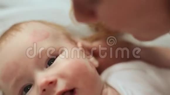 妈妈亲吻宝宝留下一丝鲜艳的口红吻痕慢速射击视频的预览图