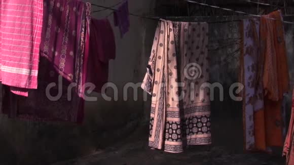 美丽的五颜六色的纱丽干燥在房子的外部摇摆视频的预览图
