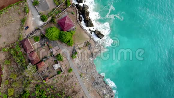 巴厘岛带岩石和绿色悬崖的沙滩鸟瞰图视频的预览图