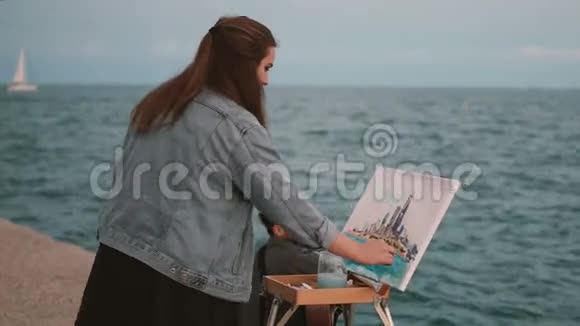 在海边的一对年轻漂亮的夫妇有创意的女人画这幅画男人弹吉他视频的预览图
