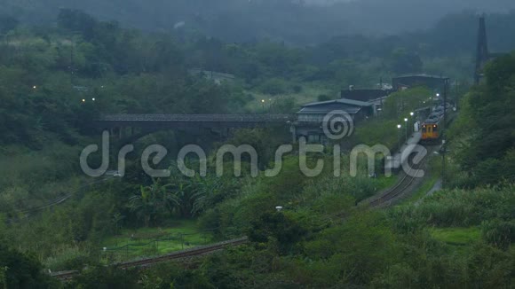 雾天气列车在一个美丽的山谷中行驶周围是青山和雄伟的山脉桥横跨视频的预览图