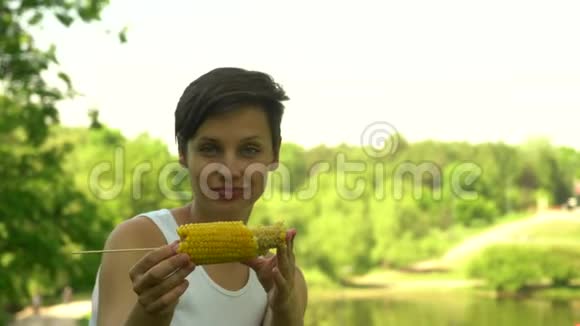 美丽的黑发女孩吃玉米视频的预览图