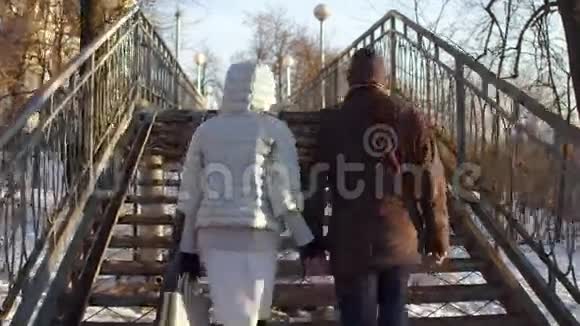 一对手牵着手走在一座充满爱锁的小桥上4克斯泰德姆视频的预览图