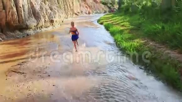 小女孩在溪流浅水中嬉戏视频的预览图