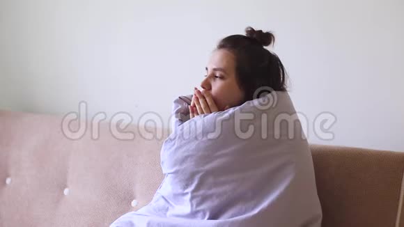 生病的年轻女子坐在家里喉咙痛咳嗽视频的预览图