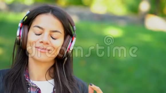 快乐混血少女听耳机音乐西班牙裔时髦女孩随节奏跳舞唱歌视频的预览图