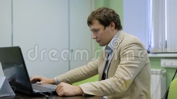 他办公室的经理在用笔记本电脑从笔记本电脑屏幕上读取信息热心的上班族一个男人视频的预览图
