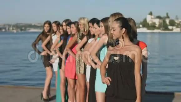 穿着连衣裙的模特们站在海边的一排视频的预览图